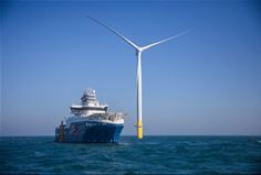 Ship going by a wind turbine at sea