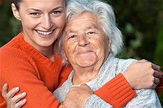 Young woman hugging old lady