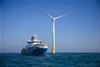 Ship going by a wind turbine at sea