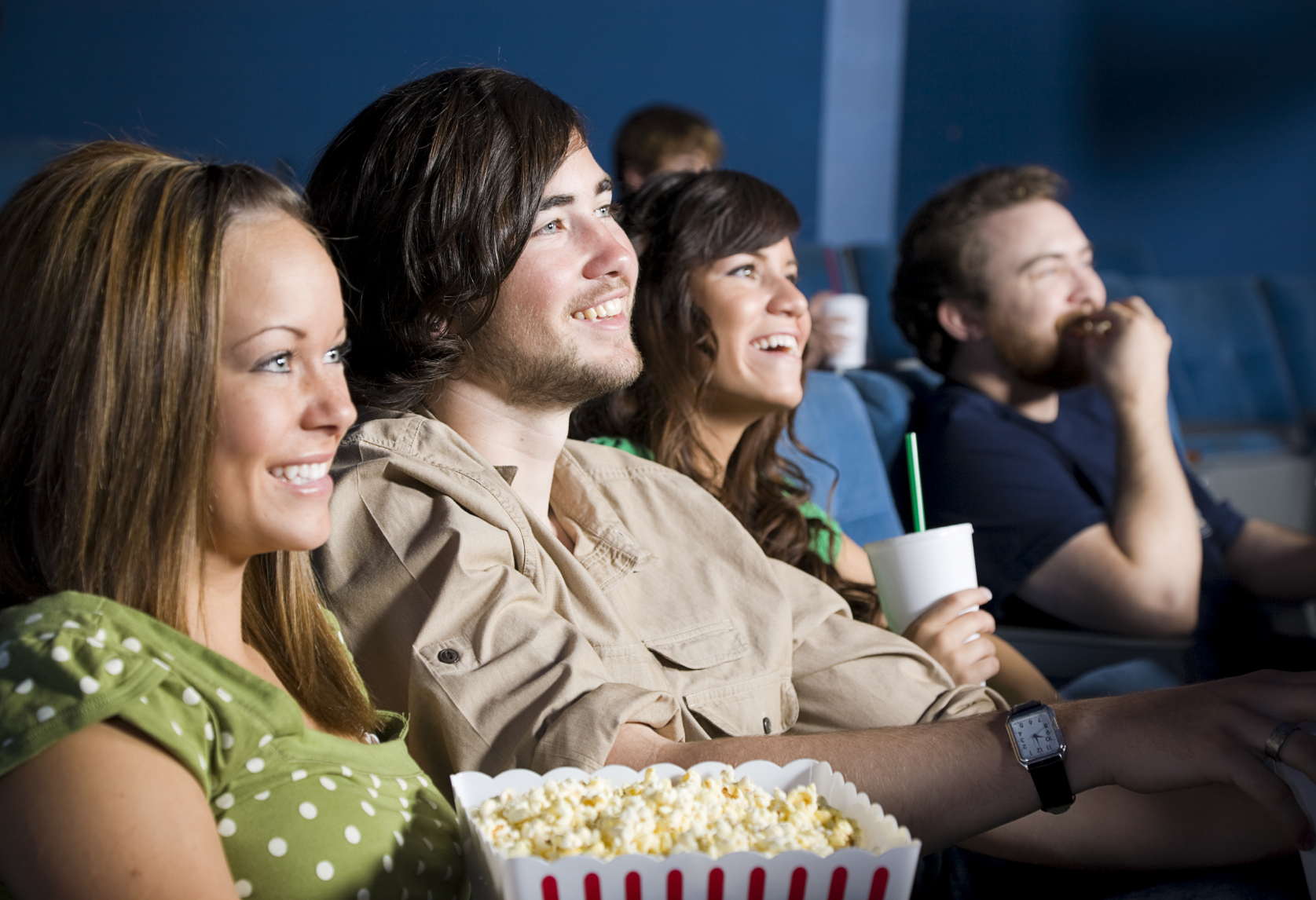 Просмотр. Компания людей смеются. Люди смеются в кинотеатре. Друзья в кинотеатре. Компания друзей в кинотеатре.